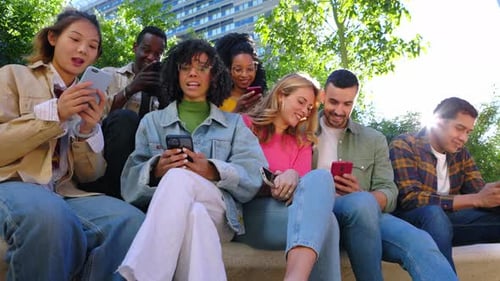 Young Adults Using Cell Phones Outside Together