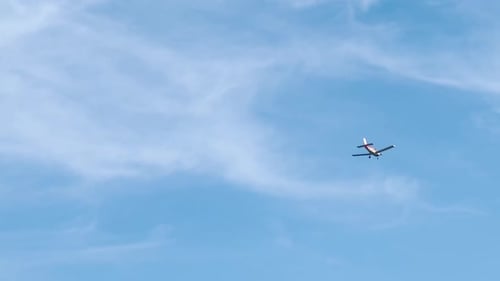 Small Plane Flying in a Blue Sky
