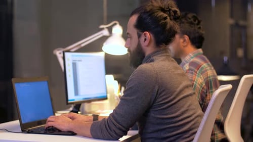 Deadline, Technology and People Concept - Programmers with Computers Working Together Late