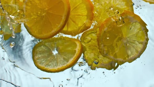 Lemon Slices Splashing Into Water, Close Up
