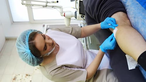 Medical Professional Bandaging Patient Arm in Clinic
