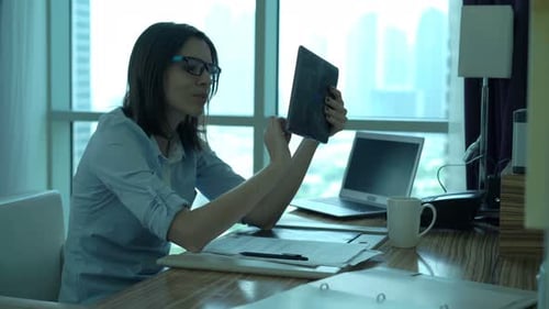 Young businesswoman browsing internet on tablet computer in modern office