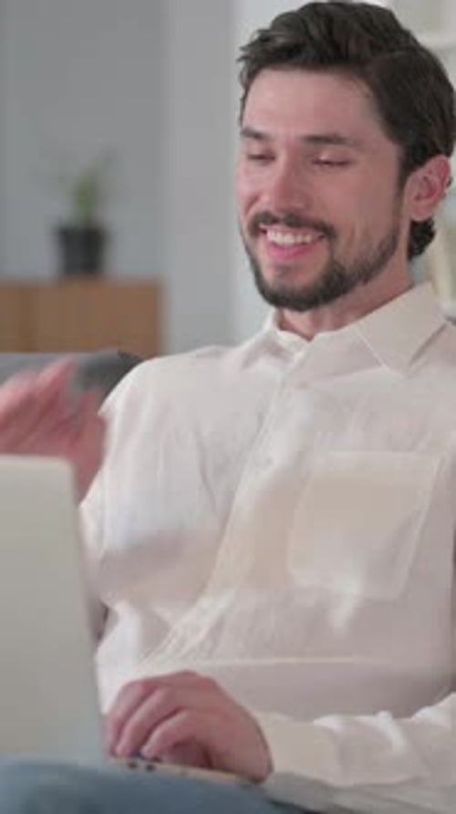 Bearded Man Waving During Video Call on Laptop