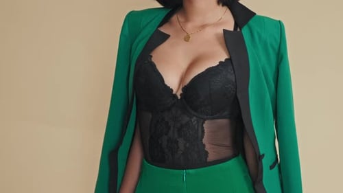 Woman in Bodysuit and Green Suit Poses