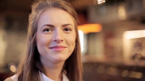 Smiling Woman Looking at Camera in Indoor Setting