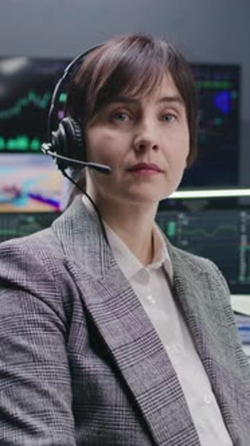 Comerciante feminina em fone de ouvido olha para a câmera