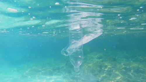 Plastic pollution in sea ocean, big environmental problem. Plastic bag and bottle floating in ocean.