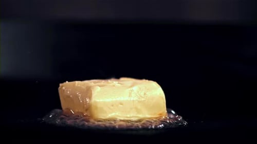 Super Slow Motion a Piece of Butter with a Fork Melts in a Frying Pan Filmed on a Highspeed Camera