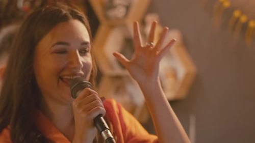 Young Woman Singing Karaoke at a Party