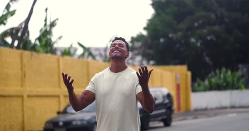 Man standing with arms raised in spiritual gratitude and devotion, head tilted back, expressing joy