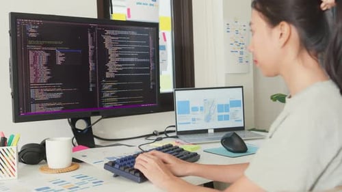 Asia girl IT development programmer typing on keyboard coding programming fixing data code.