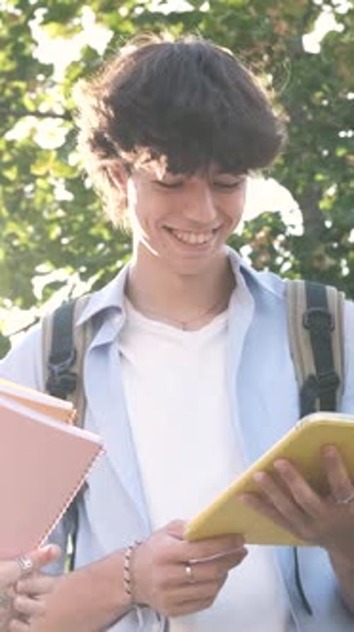 College Students Engaging in Discussion While Displaying Tablet Screen Outdoors