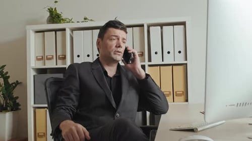 Handsome Businessman Talking on Phone in Office