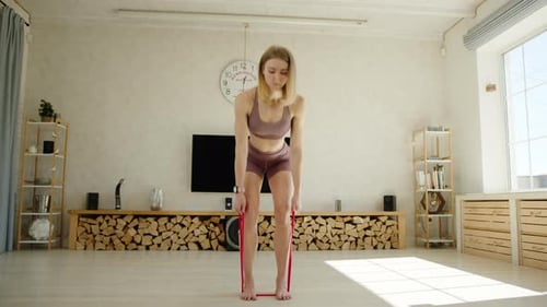 Exercises with Resistance Band Young Athletic Blonde Performs Bentover Row