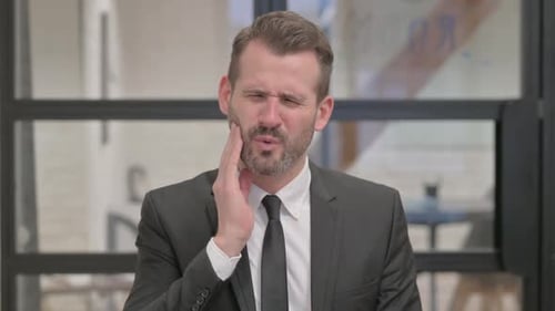 Uncomfortable Middle Aged Businessman with Toothache
