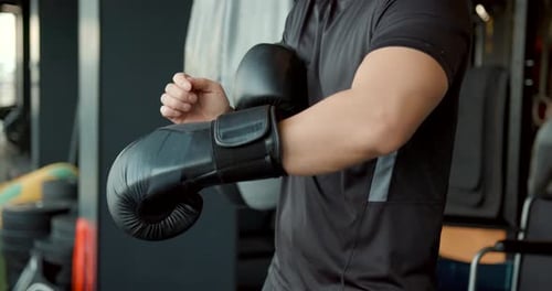 Athlete Putting on Boxing Gloves in Gym