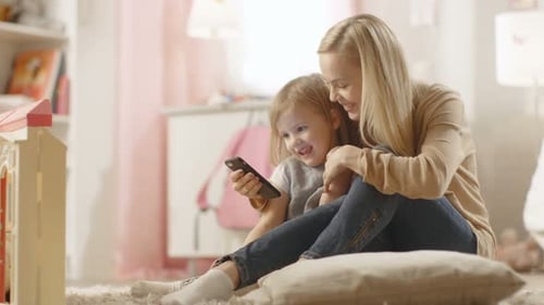 Blonde Woman Sits with Child Looking at Phone