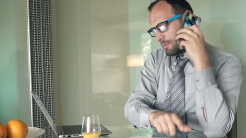 Man Working from Home on Laptop and Talking