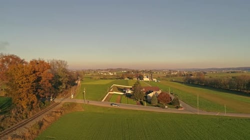 Aerial View of a Horse and Buggy Approaching a Rail Road Crossing in the Middle of the Amish Country