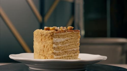 A dessert close-up of a piece of delicious honey cake lying on a white plate in Italian restaurant