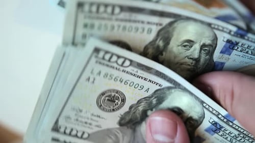 Male hands count US Dollar bills or paying in cash on white background, close up.