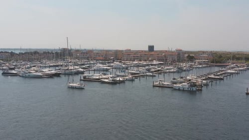Drone cinématique/vue panoramique aérienne d'un port de plaisance avec des voiliers, un bateau naviguant dans le premier