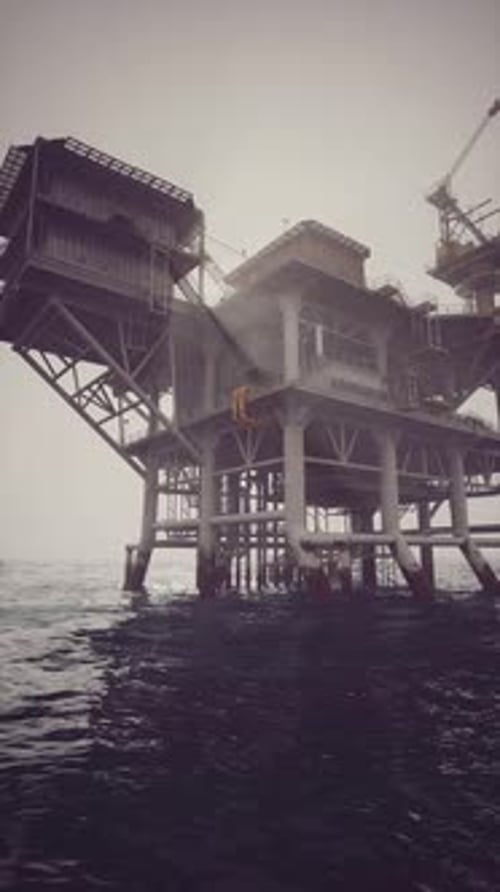 Exploring an Oil Rig Standing Tall Over Choppy Sea Waters During a Cloudy Day