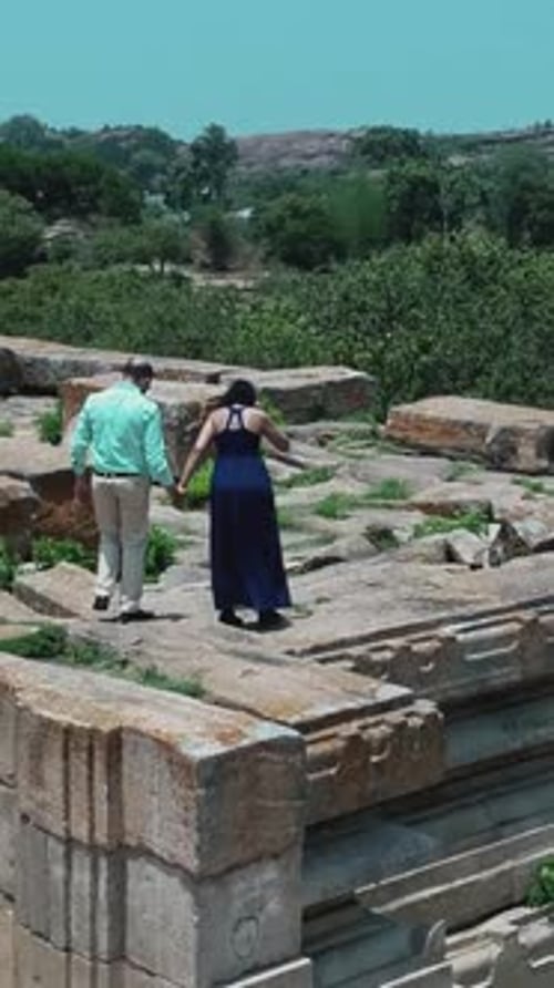 Couple indien se tenant la main marchant sur d'anciennes ruines de pierre à Melukote, Karnataka, Inde