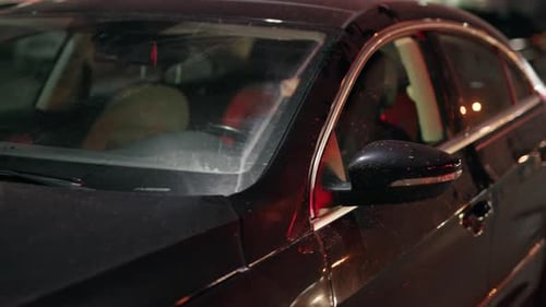 Masked Individual in Car at Night in City