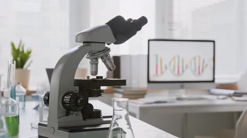 No People Shot of Microscope and Computer Displaying DNA in Laboratory