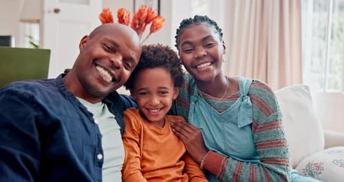 Happy Family Smiling Together on Couch at Home