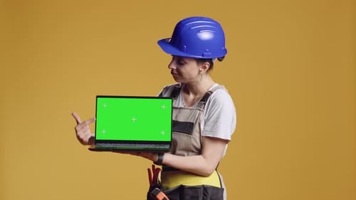 Female Construction Worker Holding Laptop with Greenscreen