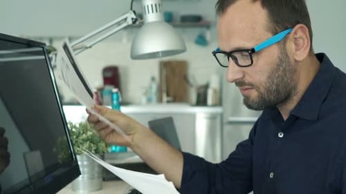 Stressed Man Working with Computer and Documents