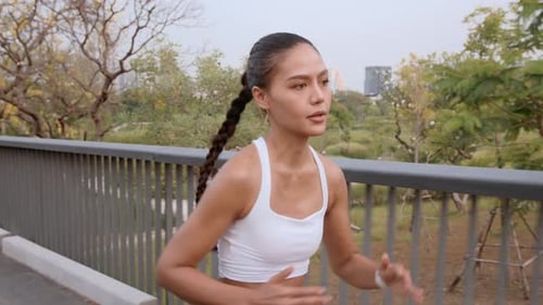Young fitness woman in sportswear jogging in city park