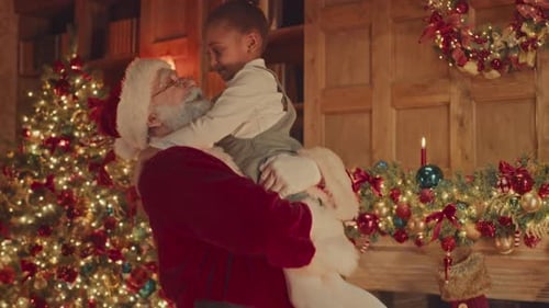 Santa Claus Hugs Child near Christmas Tree