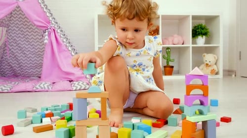 Little Girl Playing With Colorful Building Blocks At Home
