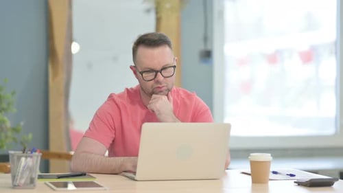 Man Working at Laptop Computer in Office