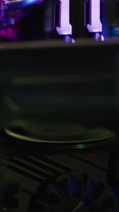 Vertical video. Gaming PC with lighting, cooler on the graphics card rotating, view insideю