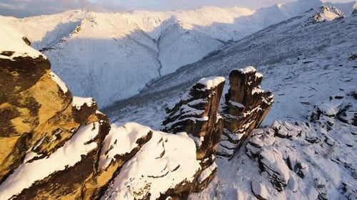 Snowy Mountains and Jagged Rocks at Sunrise