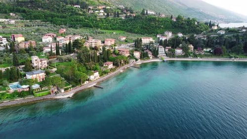 Drone Stationary Above the Beautiful City of MalcesineItaly with Houses Trees and Mountains By a