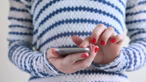 Woman Using a Smartphone in Close Up Indoors