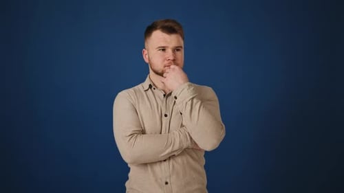 Hombre pensativo reflexionando sobre una solución sobre fondo azul