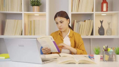 Focused Woman Studying with Books and Laptop