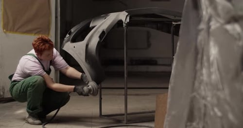 Female Painter Sanding Bumper for Priming