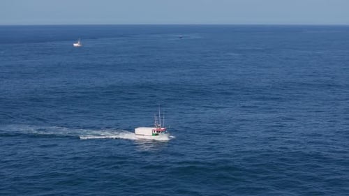 Fishing Boat Cruising In The Blue Sea In To Muxia In Spain. - aerial shot