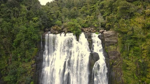 Drone moving away from a waterfall at high rocky cliff. 4K videos.
