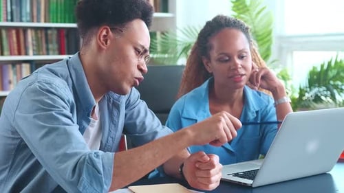 Young Students African American Woman and Man Sits with Laptop in Campus Library