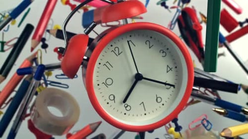 An Alarm Clock with Various School Supplies Flies Up and Falls Filmed on a Highspeed Camera at 1000