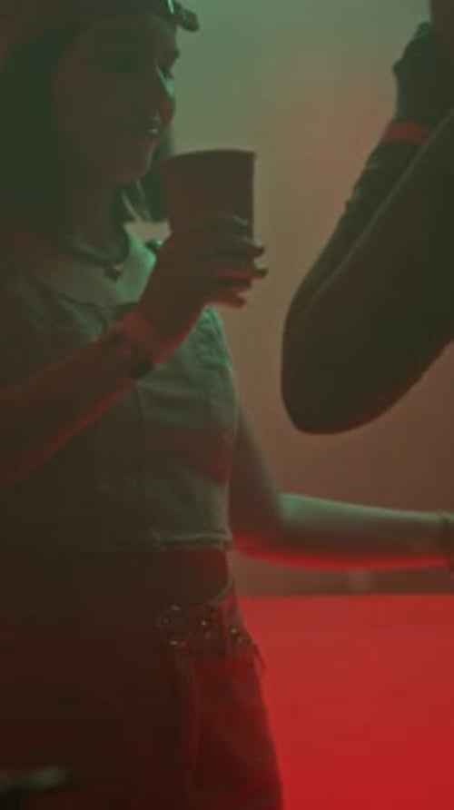 Vertical of Girl Friends Drinking Alcohol and Dancing in Club Restroom