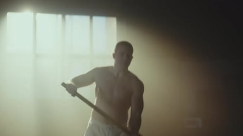 Man Doing Tire Workout With Sledgehammer Indoors